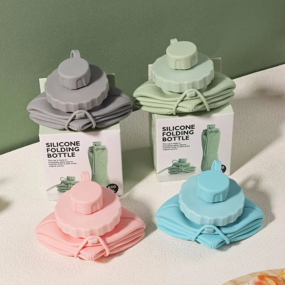 A collection of silicone folding bottles in various shades of green and blue, displayed on a white surface.