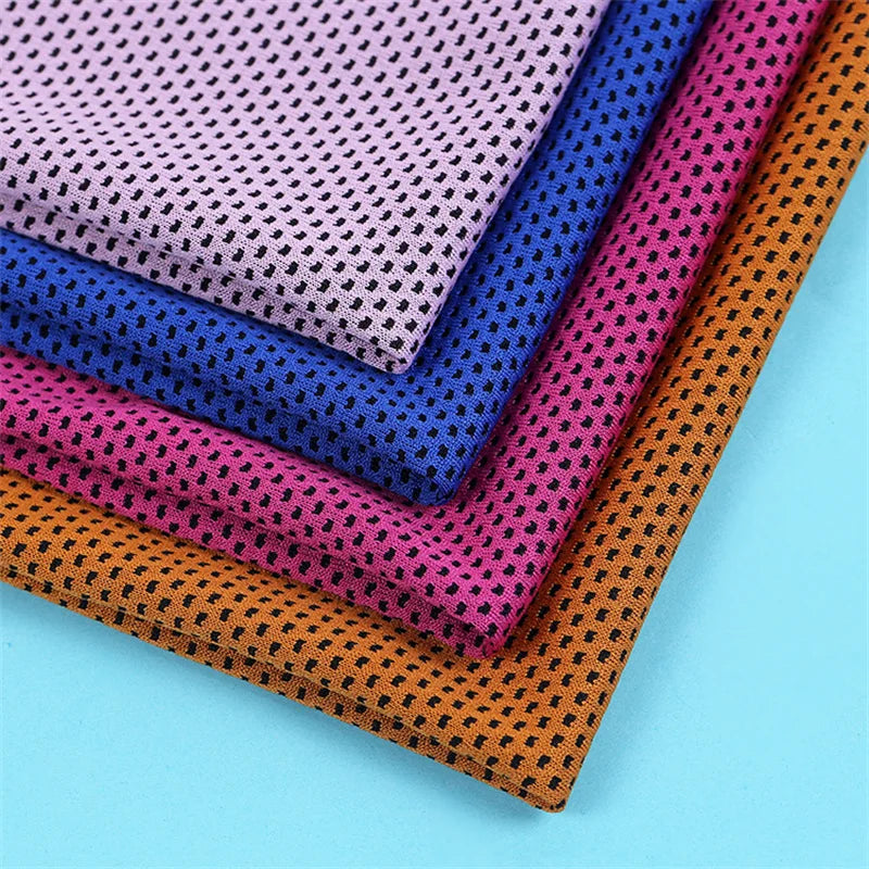 A stack of colorful microfiber cooling towels in various shades of purple, blue, pink, and orange.