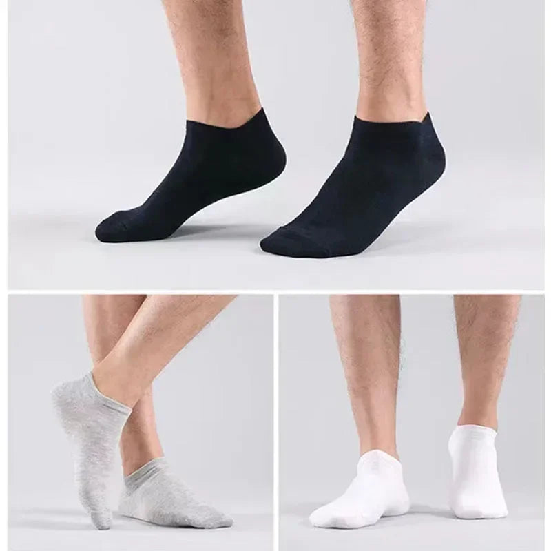 Un par de calcetines de algodón transpirables para el tobillo en blanco y negro mostrados en los pies de una persona.