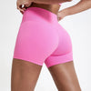 Une femme portant des shorts de yoga de compression roses vifs à taille haute.
