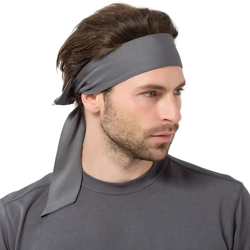A man wearing a gray breathable sports headband on his forehead, looking to the side.