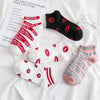 A collection of black, white, and pink novelty socks featuring red lettering and stripes on a white background.
