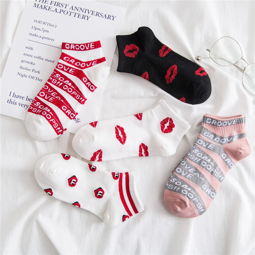 A collection of black, white, and pink novelty socks featuring red lettering and stripes on a white background.