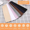 A set of seven solid elastic hair bands in various colors laid out on a gray surface.