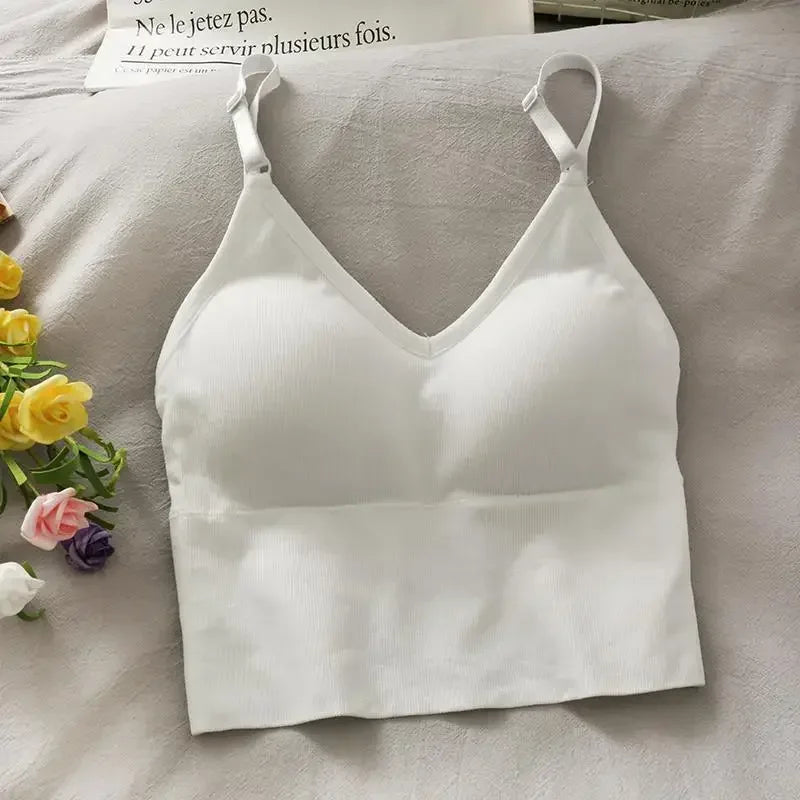 White off-shoulder camisole tank top for women displayed on a light fabric with flowers.