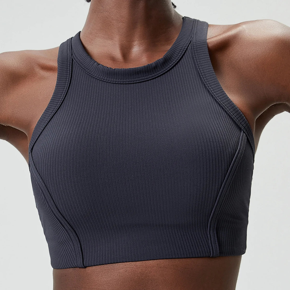 A dark gray high-impact stretch yoga crop top worn by a model.