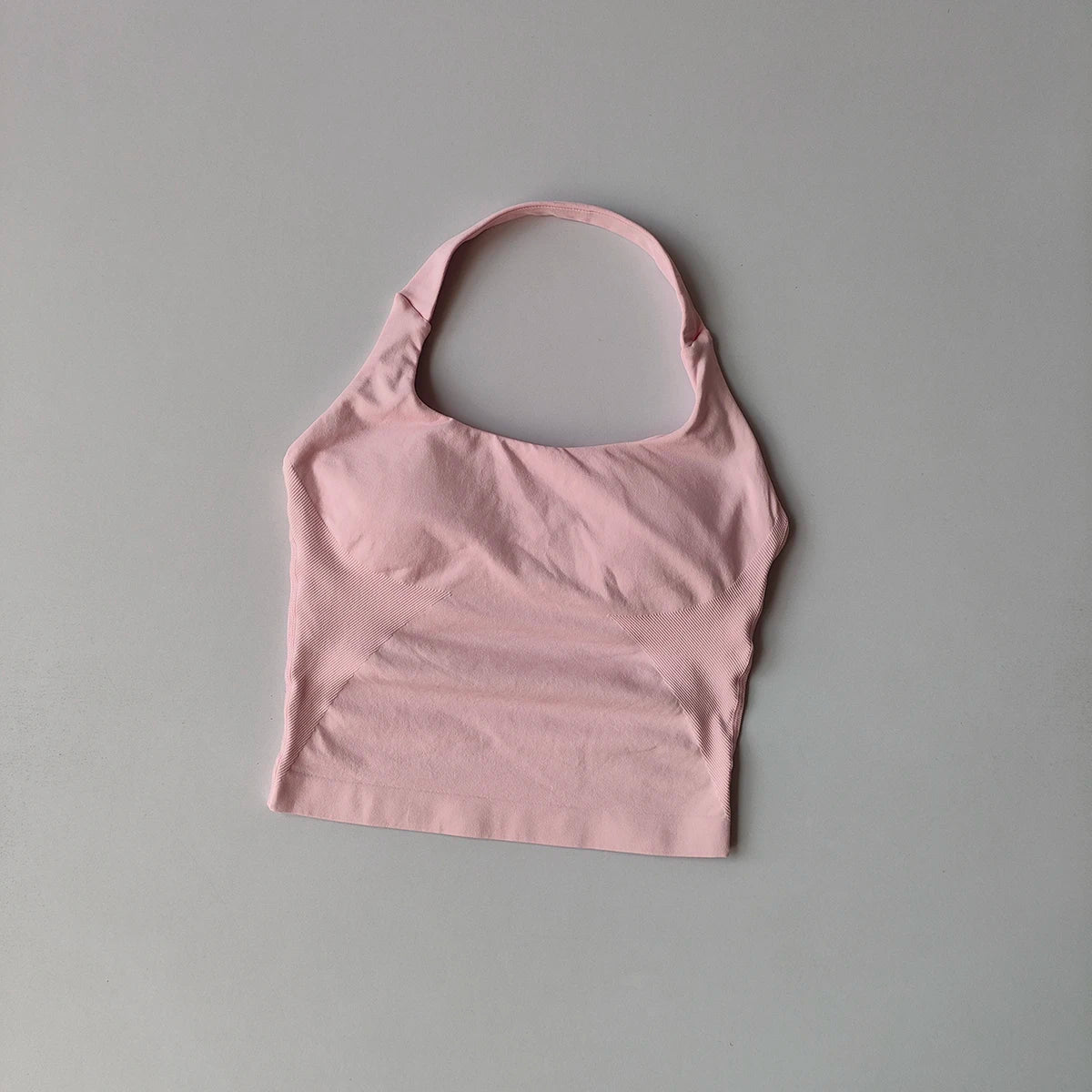 Un haut bandeau rose pâle uni, présenté sur un fond gris solide.