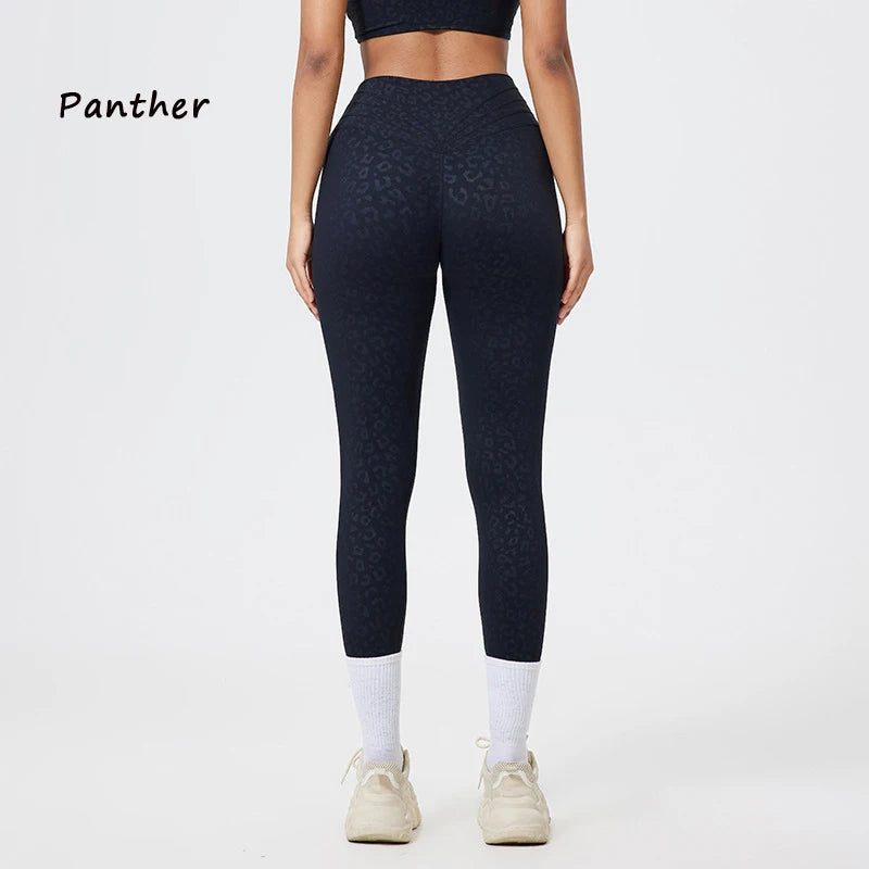 Eine Person trägt dunkelblaue, nahtlose Yoga-Leggings und ein passendes Oberteil in einer Ganzkörperaufnahme.