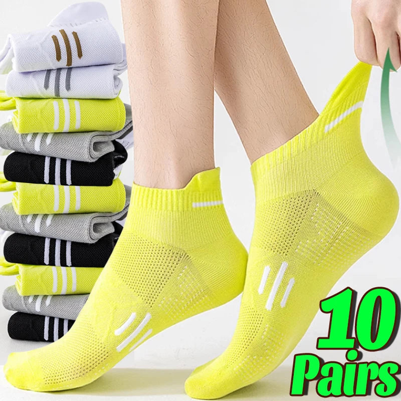 A pair of bright yellow mesh running socks is displayed on a person's foot, with multiple folded pairs visible in the backgro