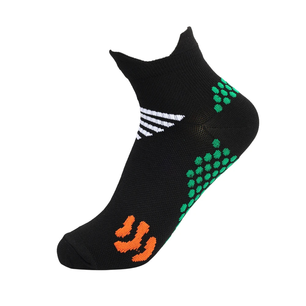Black running socks with white stripes and green dots, featuring orange detailing.