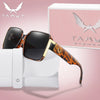 A pair of brown tortoiseshell sunglasses resting on a white cloth next to a pink box.