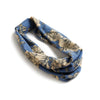 A blue and beige floral patterned cotton stretch headband folded and displayed on a white background.