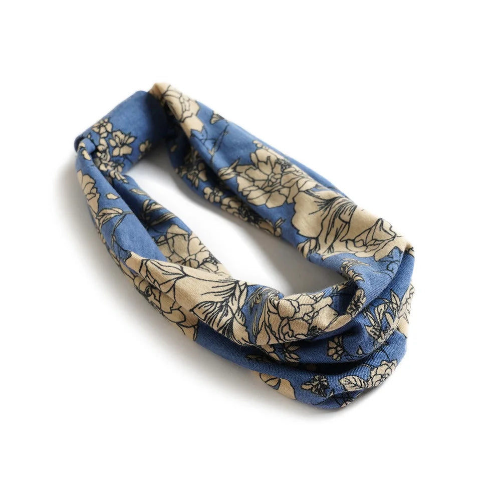 A blue and beige floral patterned cotton stretch headband folded and displayed on a white background.