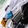 A close-up of men's color-block mesh ankle socks in various shades of gray, white, black, and blue.