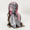 A flowing satin square scarf featuring a marbled pattern of gray, black, and pink tones