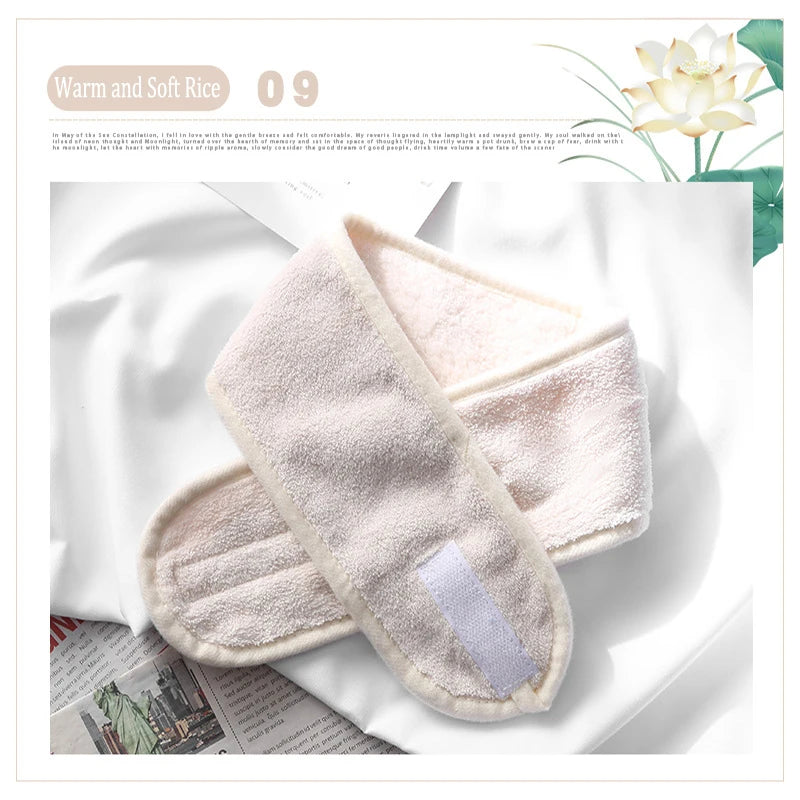 A pair of soft, light pink faux fur hair accessories lying on a white background next to some paper and a plant.