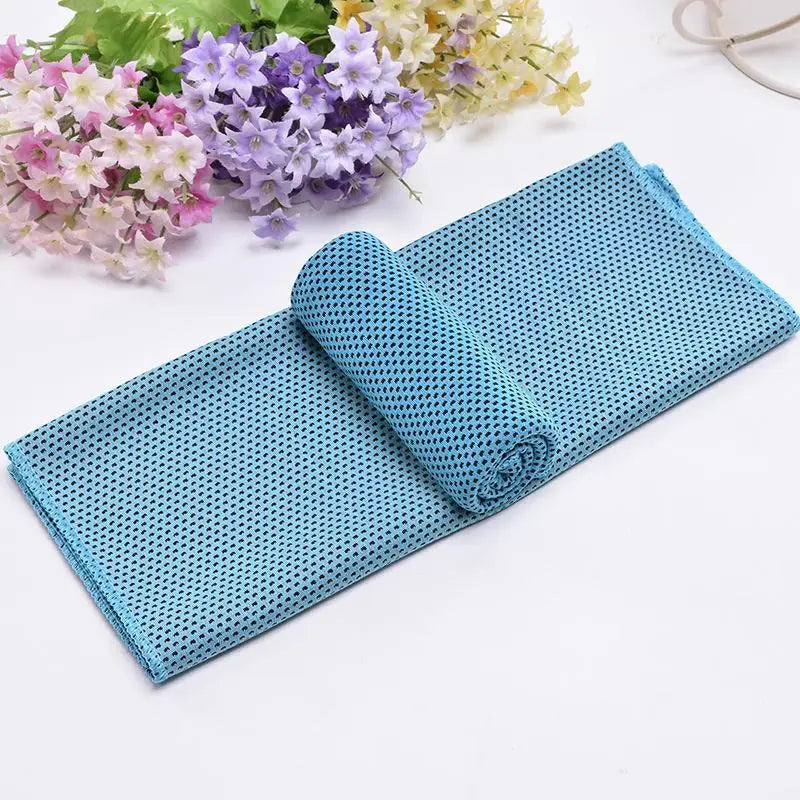 Serviette de refroidissement circulaire bleu sarcelle roulée sur une surface blanche avec des décorations florales en arrière