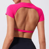 A woman wearing a bright pink women's fitness crop top yoga and gym t-shirt, shown from the back.