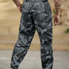 Pantalon cargo camouflage pour homme, motif vert foncé et noir.