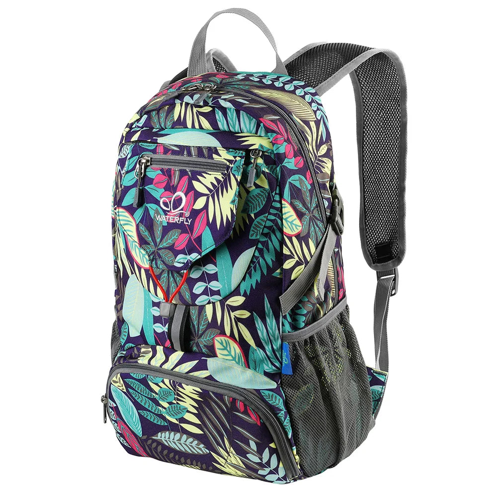 A purple and green patterned ultra-light foldable travel backpack with gray straps.