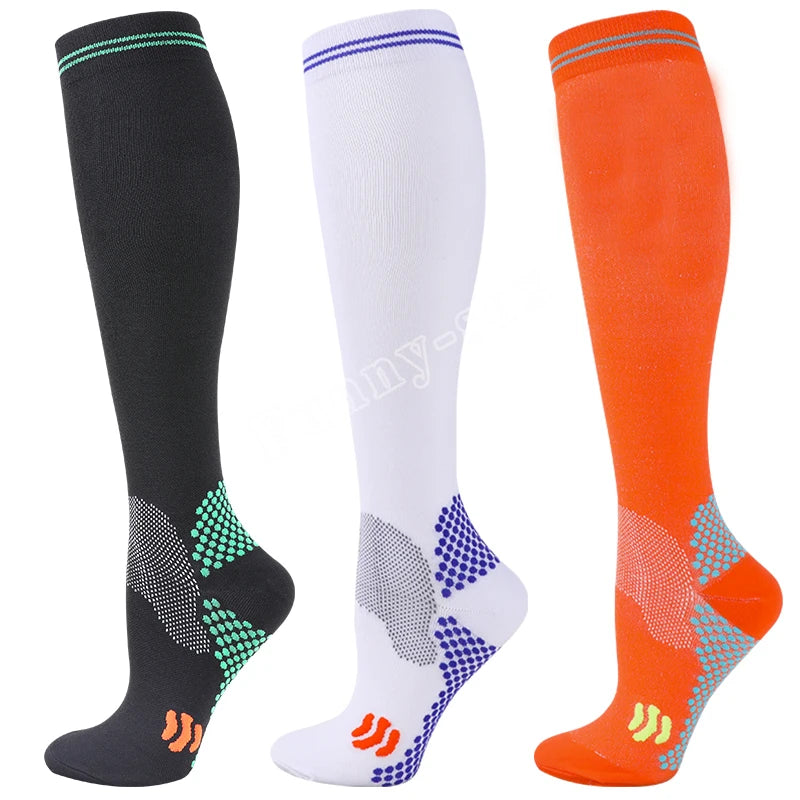 Three pairs of medical grade compression socks in black white and orange showing different patterns.