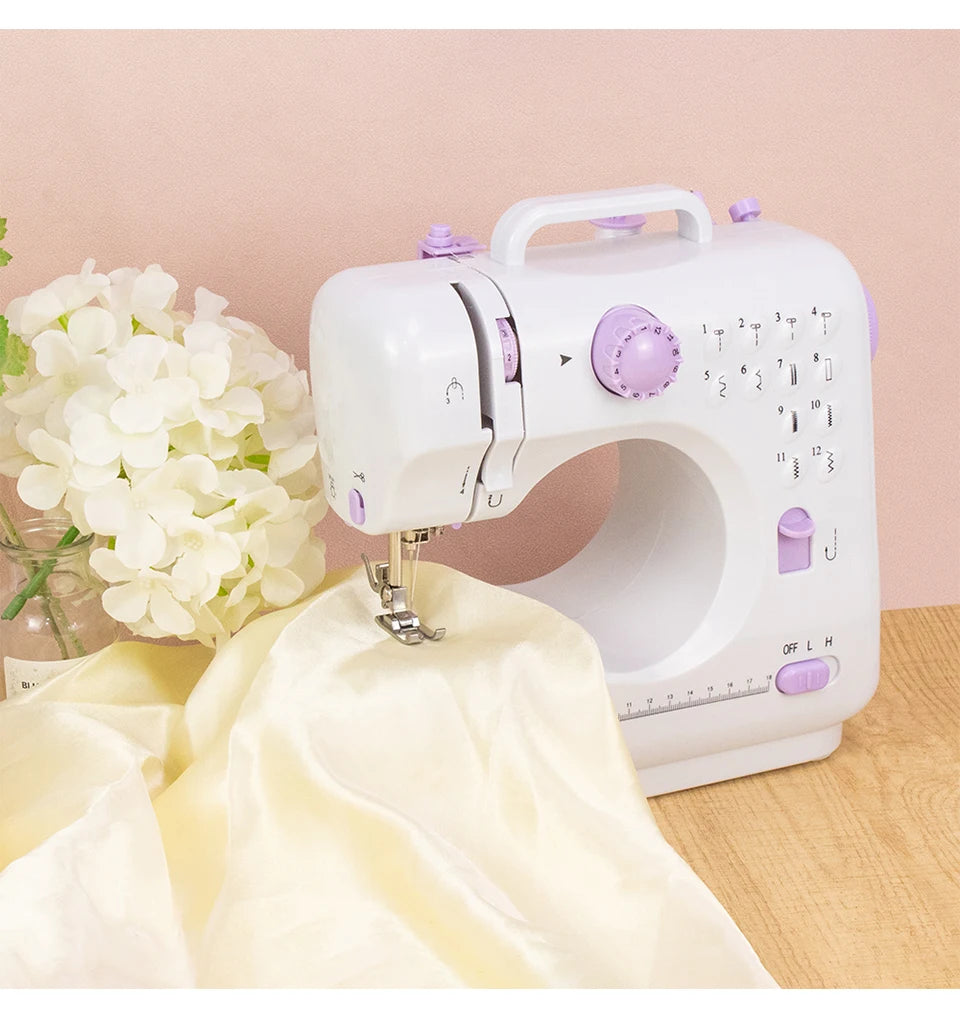 Weiße portable Mini-Nähmaschine mit einem Stück cremefarbenem Stoff auf einer Holzoberfläche.
