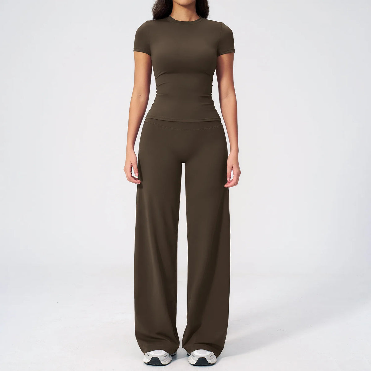 A woman wearing a solid brown high-waist yoga and gym leggings set.