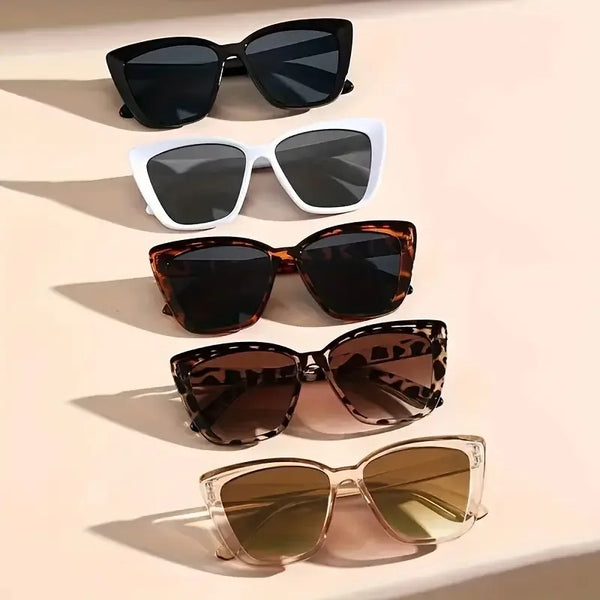 A collection of five pairs of cat eye vintage sunglasses in various shades and frames displayed on a light background.