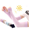 A person is wearing a long, light purple compression sleeve or ice sleeve on their arm, with various colored sleeves laid out