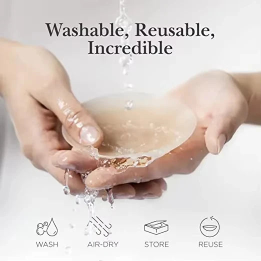 Mains tenant une coque de sein en silicone translucide, dégoulinant de l'eau, montrant la nature lavable et réutilisable du p