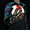 A hand wearing black and gold goalkeeper gloves is holding a white soccer ball against a dark background.