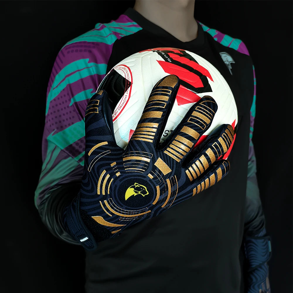 A hand wearing black and gold goalkeeper gloves is holding a white soccer ball against a dark background.