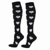Pair of black compression elastic socks decorated with white heart patterns