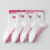 Un ensemble de chaussettes de yoga blanches avec broderies roses et adhérence antidérapante à l'orte.
