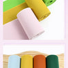A collection of rolled elastic bands in various shades of green, yellow, pink, and coral for sewing and decoration.