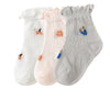 A pack of three thin summer casual baby socks in white, pink, and gray with small floral or abstract designs.