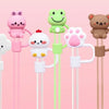A collection of colorful silicone straw covers shaped like animals, including a duck, a rabbit, a frog, a bear, and a flower.