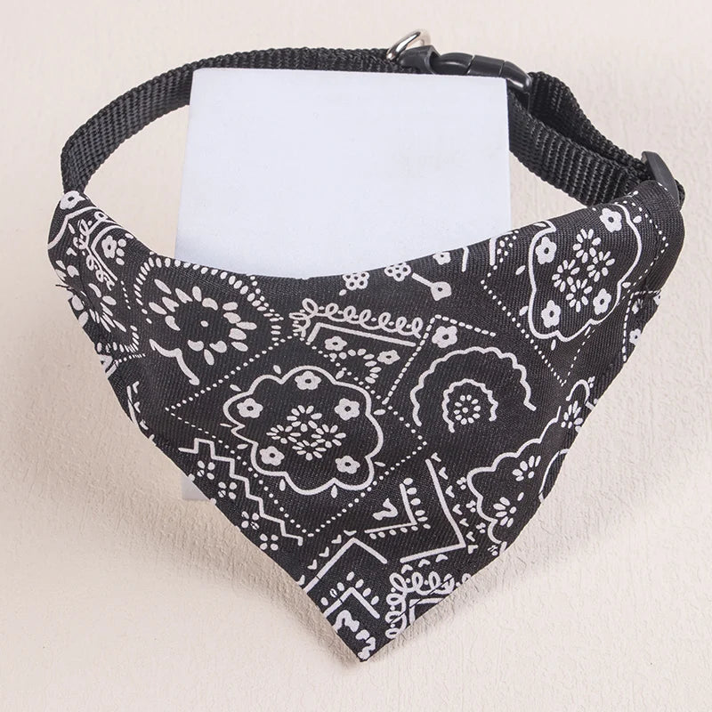 Black and white patterned adjustable pet scarf for dogs and kittens with a white tag.