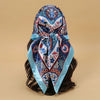 Elegant blue and white patterned satin square scarf tied around dark hair
