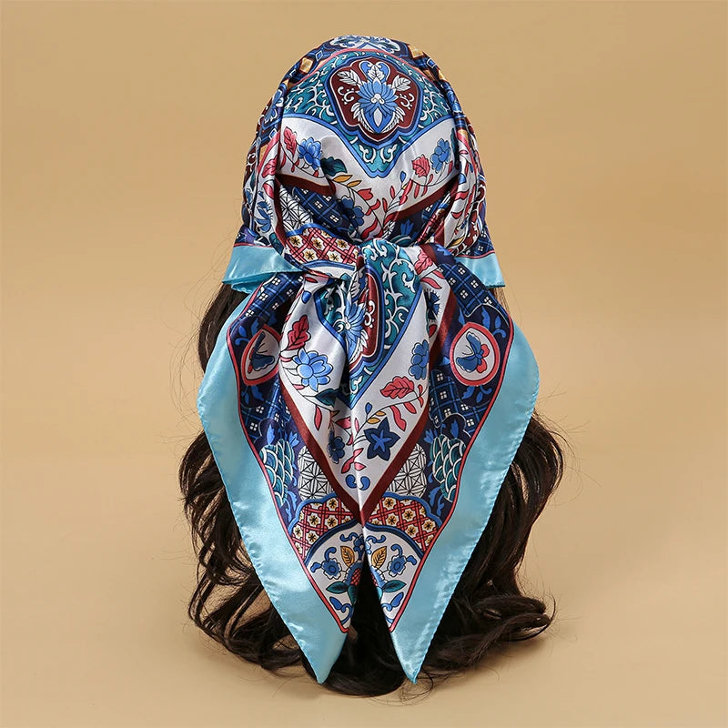 Elegant blue and white patterned satin square scarf tied around dark hair