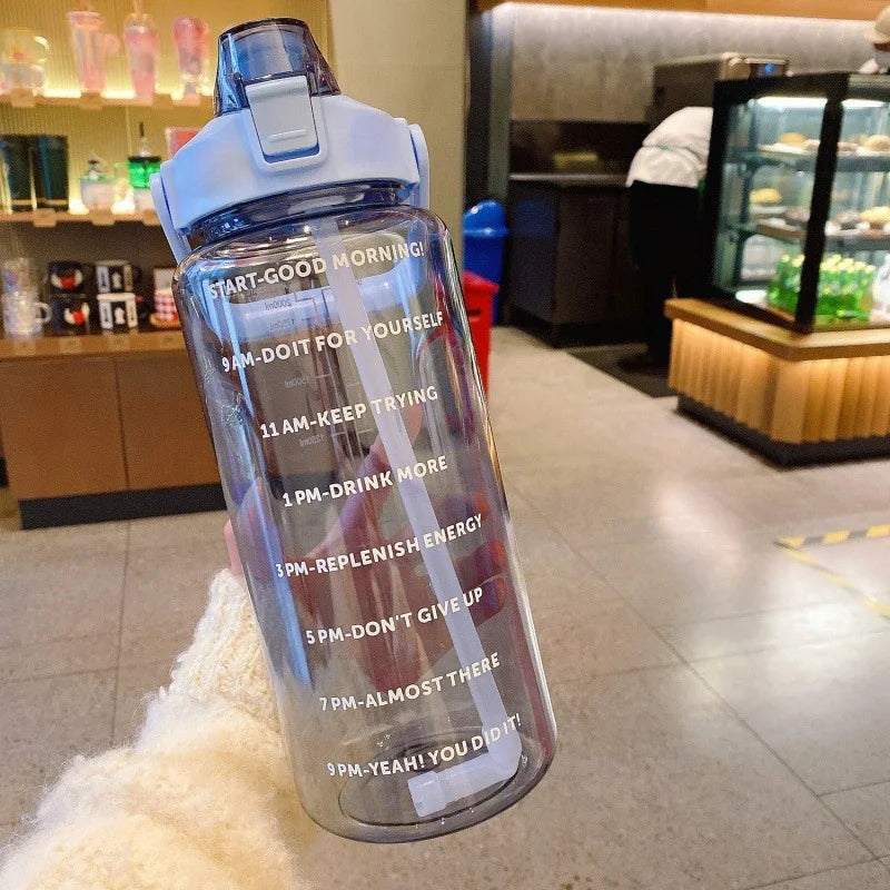 Bouteille d'eau sportive transparente remplie de liquide et marquée d'intervalles de temps pour les objectifs d'hydratation q