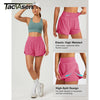 Eine Frau modelliert pinke, hochgeschnittene Sportshorts und ein passendes Sport-BH-Top.