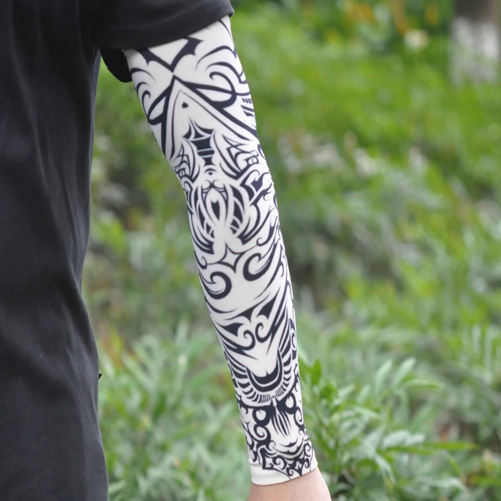 Close-up of a person wearing black clothing and white ice silk tattoo sleeves with black ornamental designs.