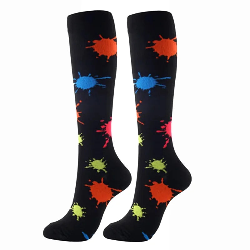 A pair of black compression elastic socks featuring colorful splatter patterns in orange, blue, and green.