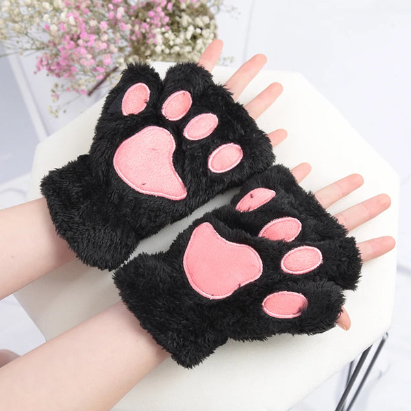 Mitones de garras de gato de peluche negro con almohadillas rosadas sostenidos por una mano