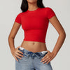 Una mujer vistiendo una camiseta y jeans de yoga y fitness rojos de secado rápido.