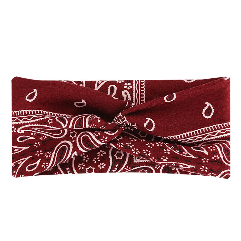 A burgundy fabric headband with white bohemian paisley print folded and tied