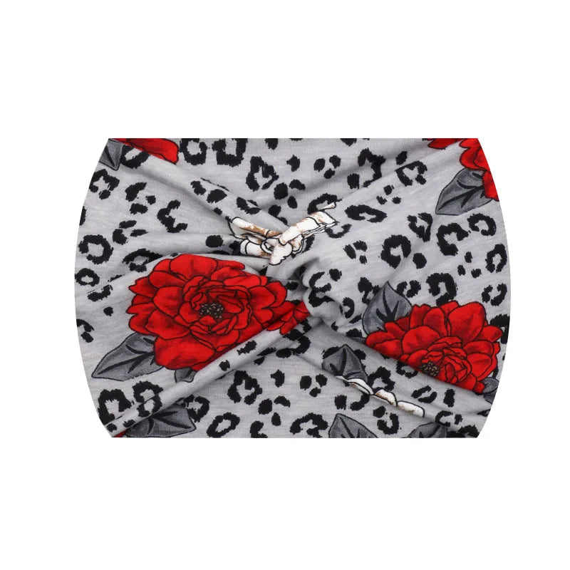 A gray fabric headband featuring a leopard print pattern and large red floral accents.
