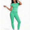 Una mujer modela un conjunto de yoga sin costuras, de cintura alta y color verde brillante, con top de manga corta y leggings
