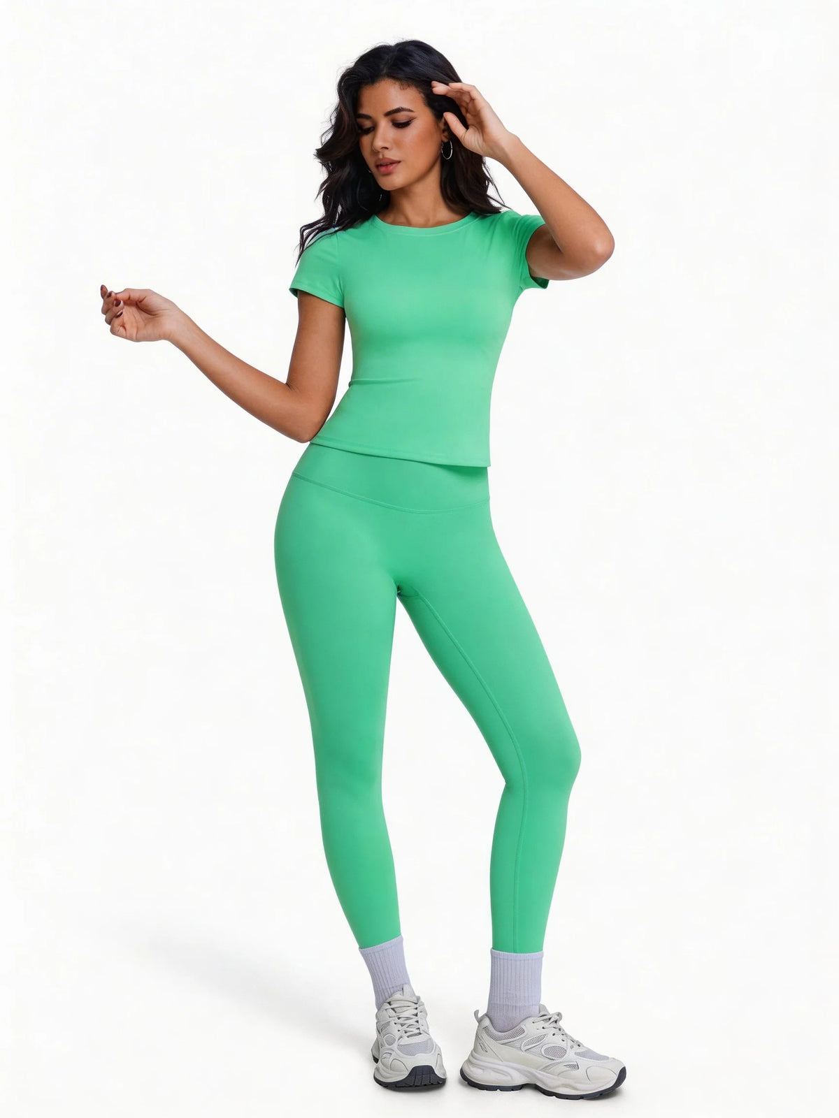 Una mujer modela un conjunto de yoga sin costuras, de cintura alta y color verde brillante, con top de manga corta y leggings